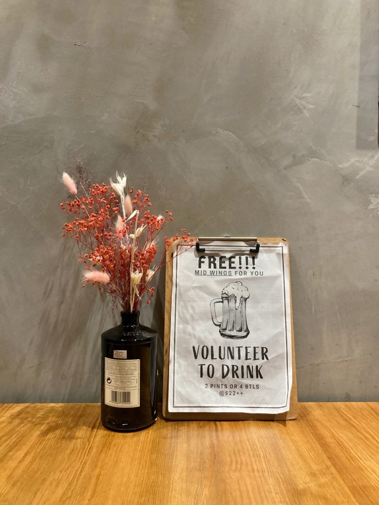 Flowers and beer-drinking ad on one of the tables at The Communal Place cafe