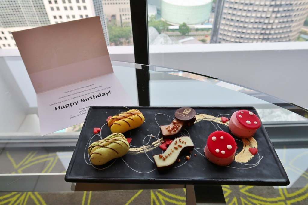 A dessert platter with a birthday card from Pan Pacific Hotel