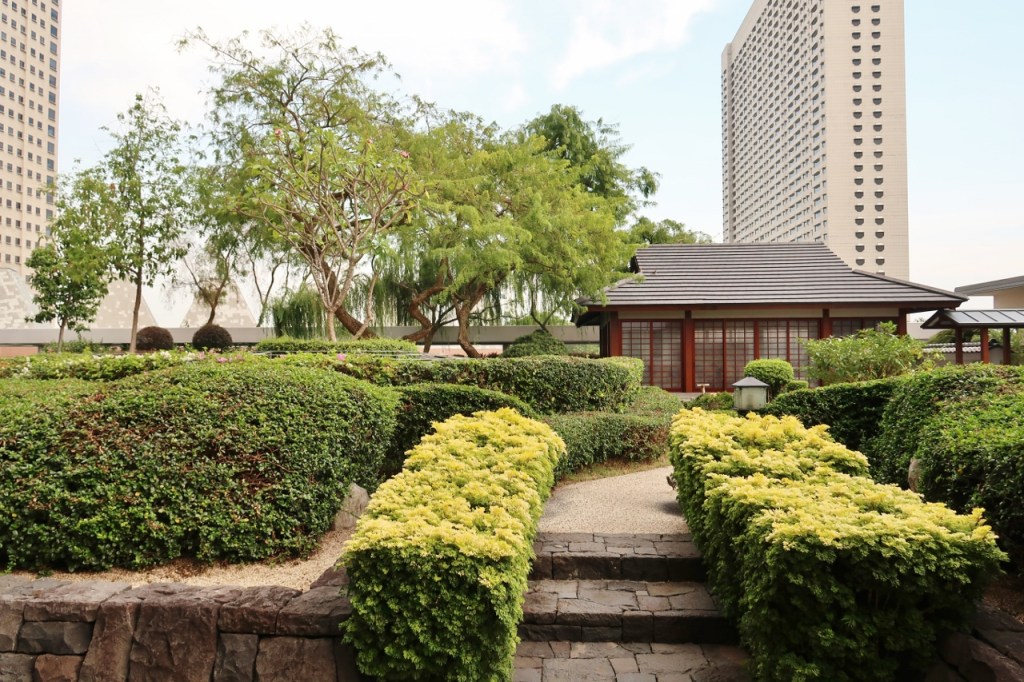 A walkway of lush greenery leading to Pan Pacific Hotel's Keyaki garden pavilion and Japanese restaurant