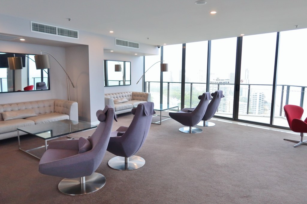 Guest lounge with comfy sofas and armchairs and floor-to-ceiling windows at Rhapsody Resort
