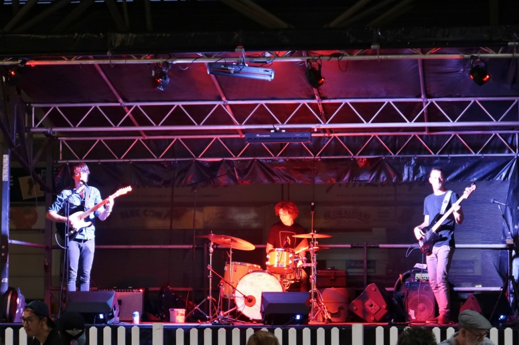 A three-man blues band performing on stage at Brisbane Night Market