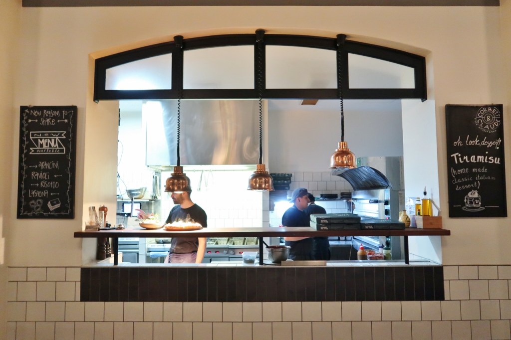 Window opening into the kitchen at Corbett & Claude Restaurant