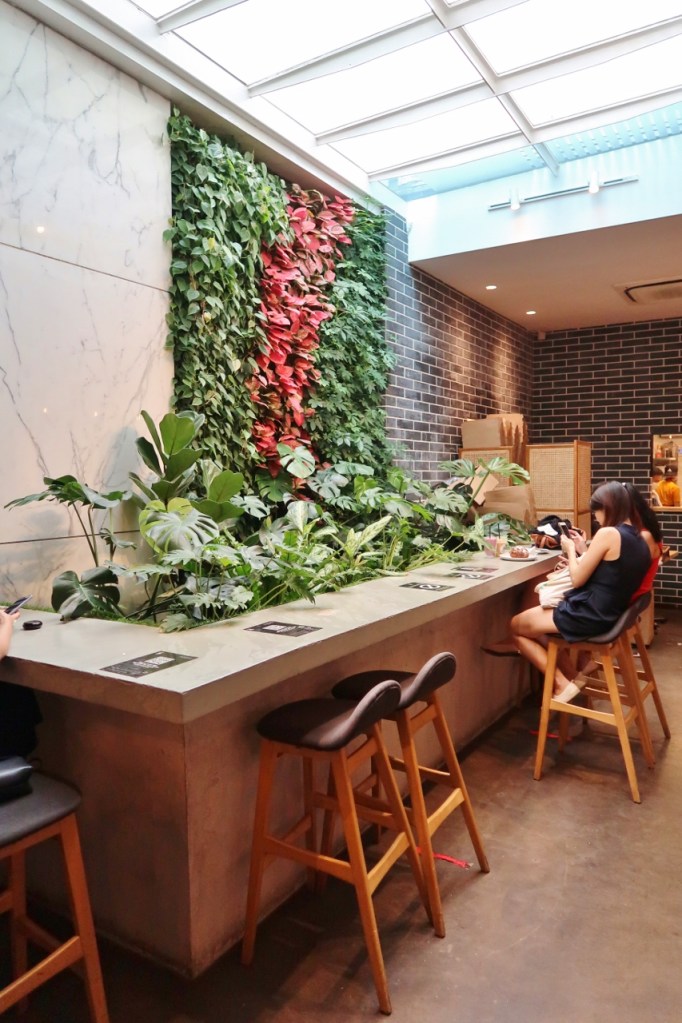 High tables dining area and greenery wall at Baristart Coffee cafe