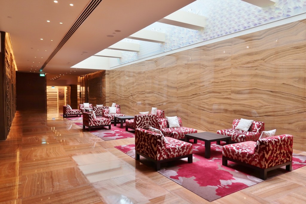 Wide corridor with comfy red armchairs and carpets at Grand Hyatt hotel