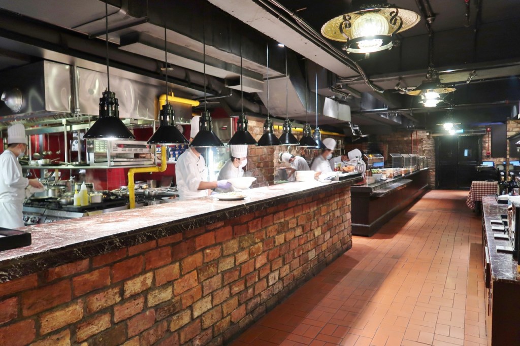 Chefs cooking behind the counter at Pete's Place restaurant at Grand Hyatt hotel