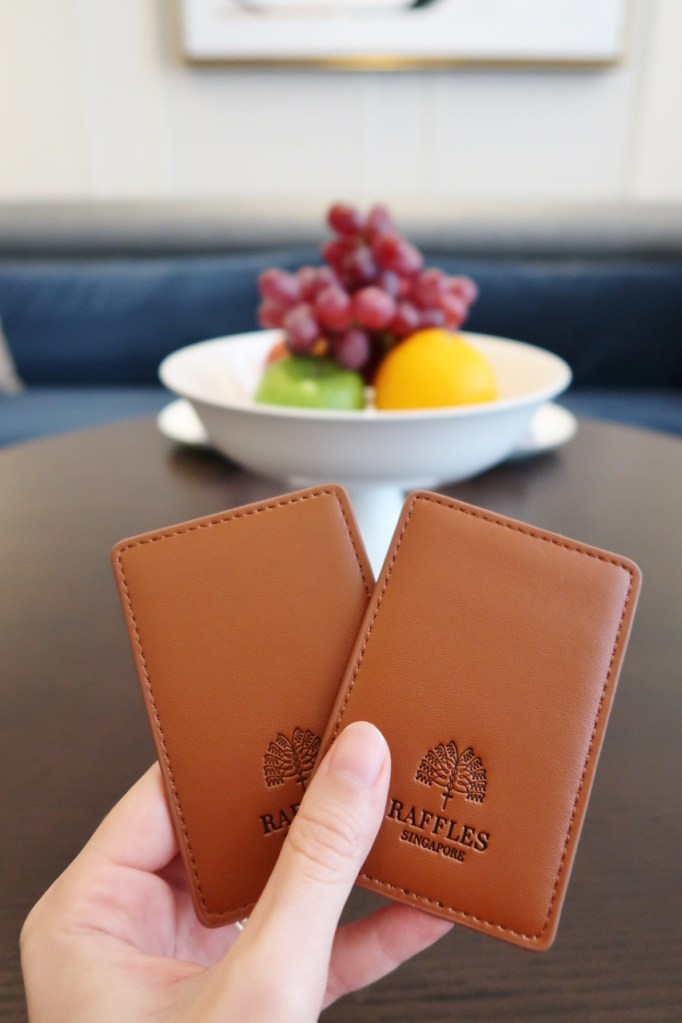 Brown leather-bound keycards to our State Room Suite at Raffles Hotel
