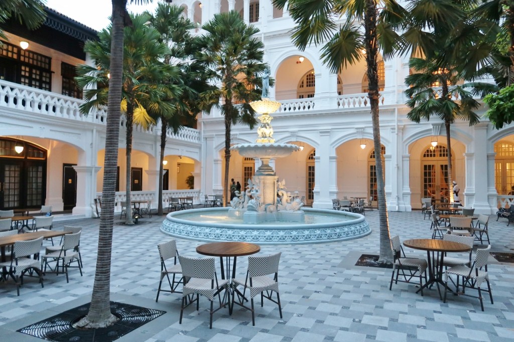 Alfresco seating area with a fountain outside Osteria BBR by Alain Ducasse restaurant at Raffles Hotel