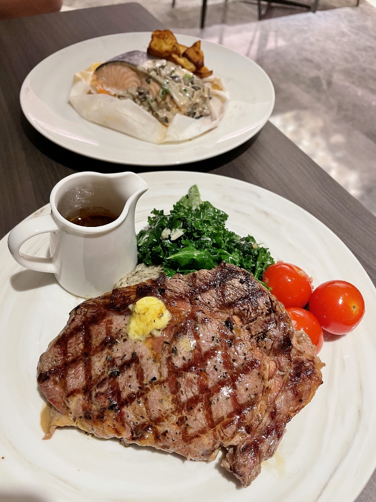 Ribeye steak and salmon dishes from SE7ENTH restaurant at Oakwood Premier AMTD Hotel & Serviced Apartments