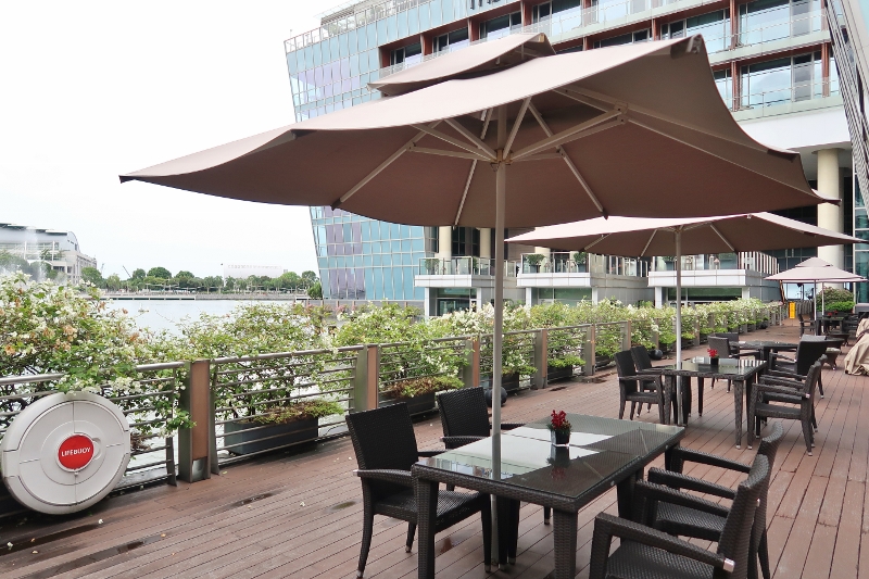 Outdoor seating area at The Landing Point restaurant at The Fullerton Bay Hotel