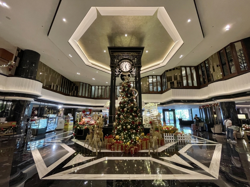 Grand clock tower with Christmas decorations in the lobby of Orchard Hotel
