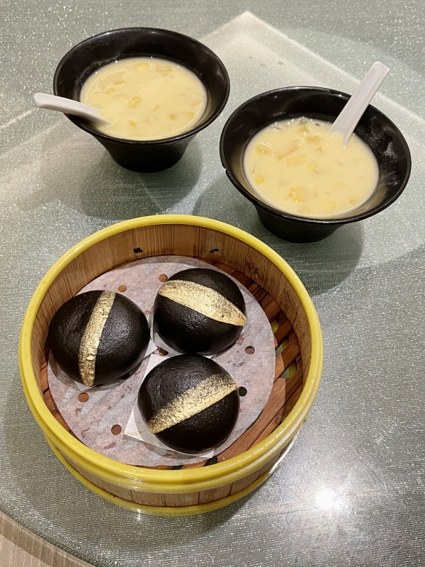 Two bowls of chilled mango, sago and pomelo and a basket of steamed creamy custard buns from Jia He Chinese Restaurant at One Farrer Hotel