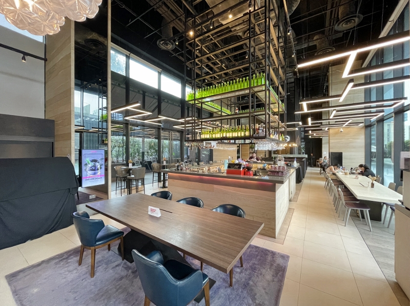 Seating area at Komyuniti restaurant at YOTEL Orchard Hotel