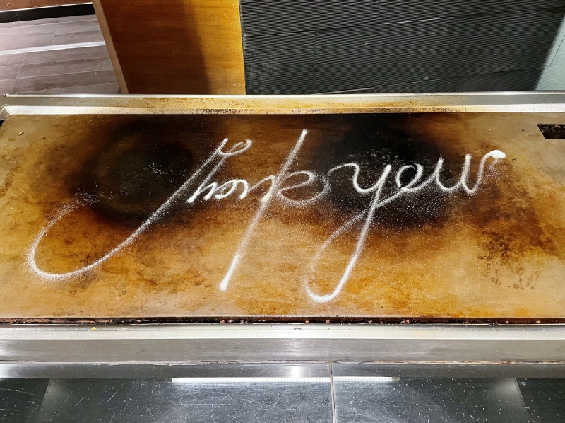The word "thank you" written with salt on the teppanyaki grill