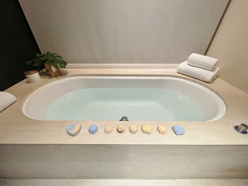 Bathbombs lined up along the bathtub in Premier Garden Room at Capella Hotel