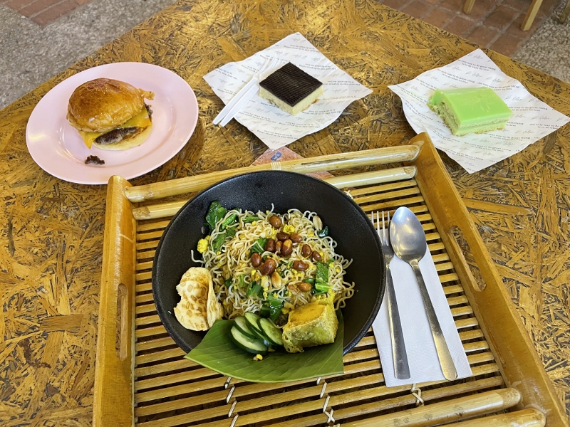 Garlic soy indomee, single beef burger, boston cream pie and pandan slice cake at The Background food hall at REXKL Arts & Culture Hub