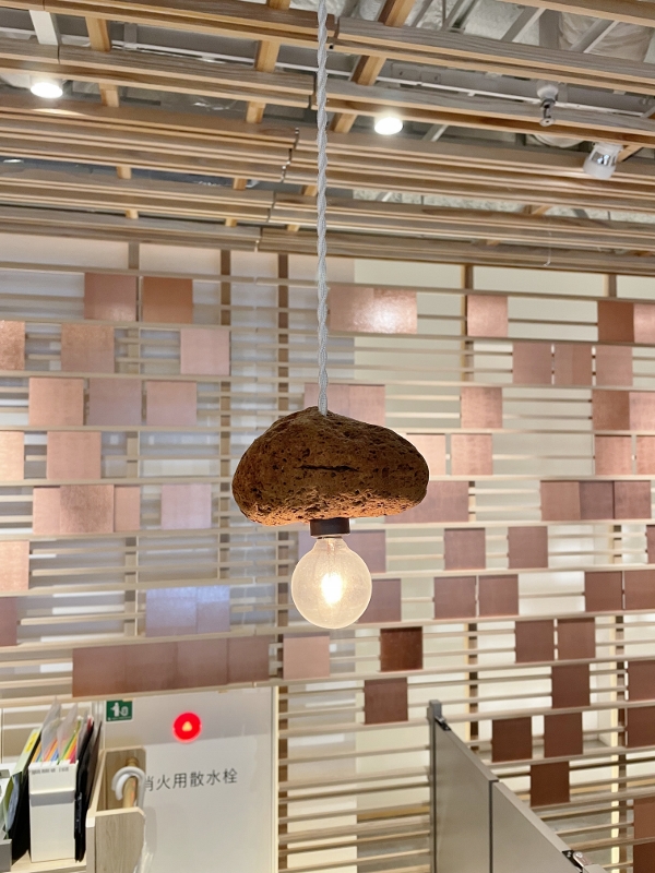 Lava rock light above reception counters at Good Nature Hotel Kyoto