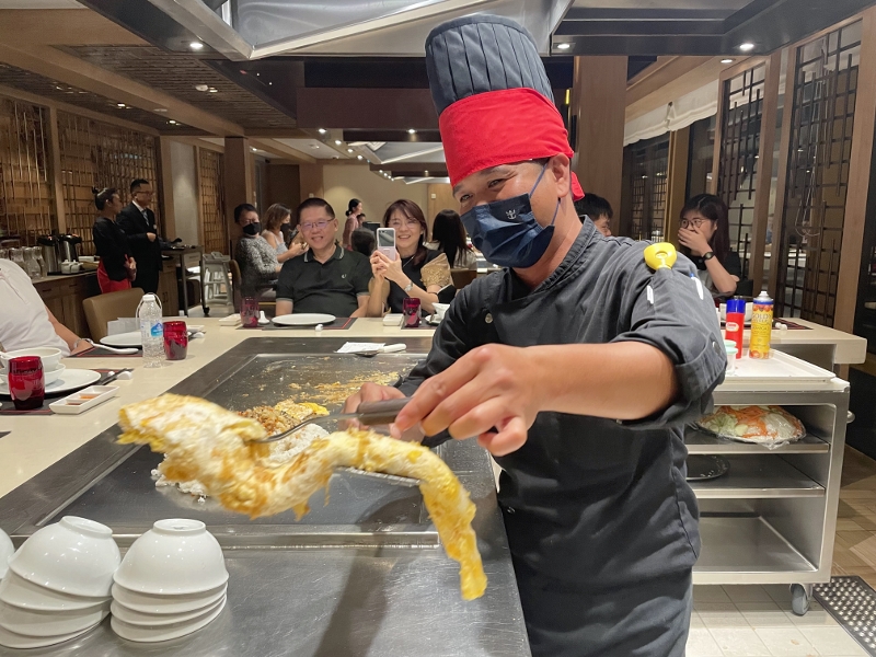 Chef interacting with guests at Izumi Teppanyaki restaurant on Royal Caribbean Spectrum Of The Seas
